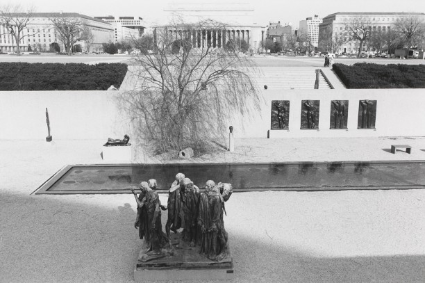 Untitled (Sculpture with men's group in foreground)