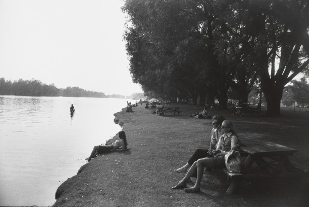Untitled (Woman and man seated at a picnic table along river)