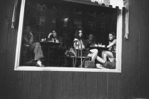 Untitled (Women and man seated at a table in restaurant behind glass window)