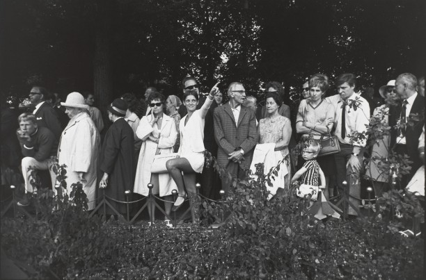 Untitled (Group of people in park, woman in center is pointing)