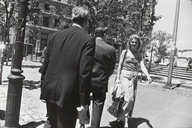 Untitled (Two men in suits passing a young woman carrying a shopping bag)