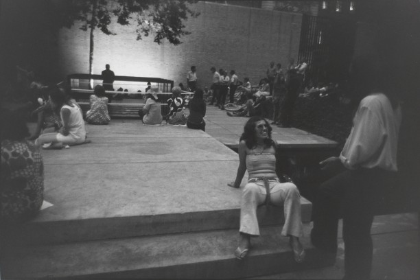 Untitled (People gathered in MOMA's outdoor courtyard, woman seated smiling up at a man)