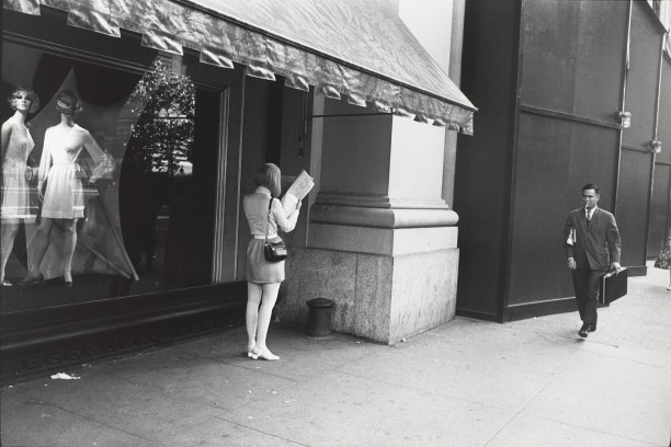 Untitled (Woman reading a paper under a shop awning)
