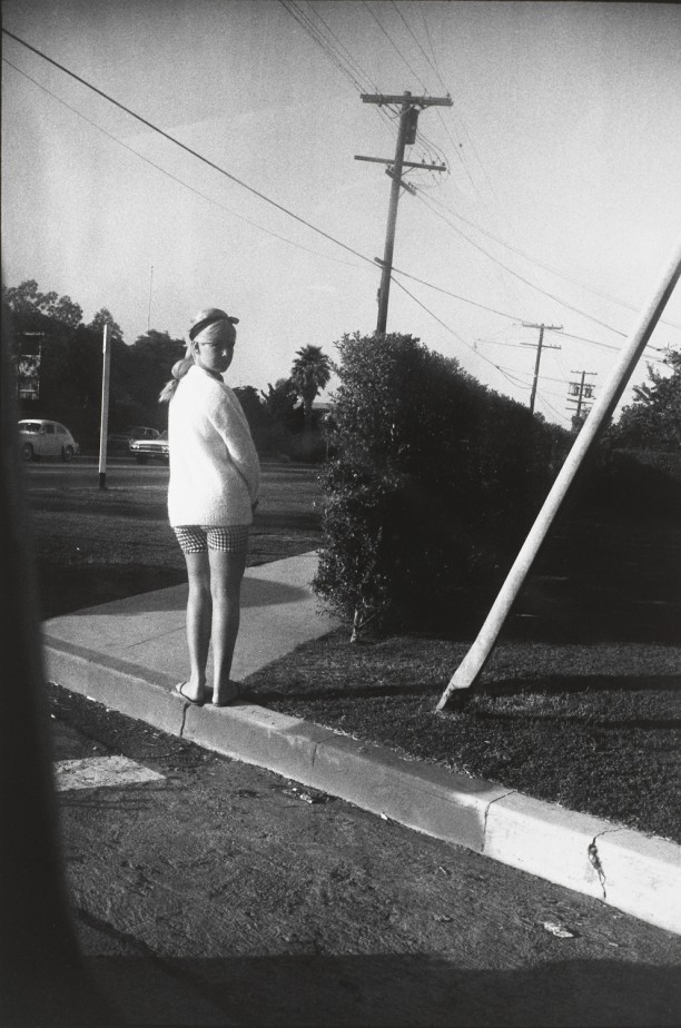 Untitled (Woman in white sweater and checkered shorts with back to camera)