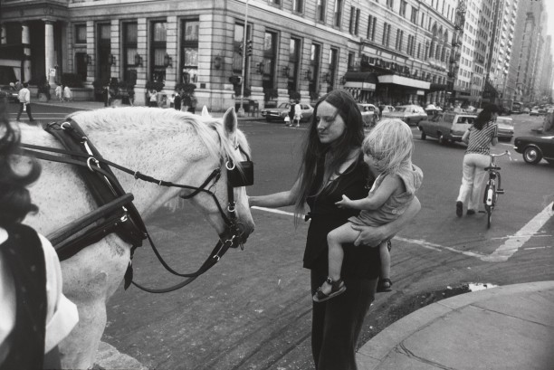 Untitled (Woman holding a child and petting a horse on the street)