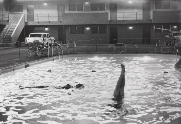 Untitled (Woman floating in a motel pool, at night)