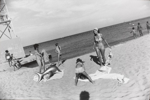 Untitled (Two women on a beach with a child and a blow up dolphin toy)